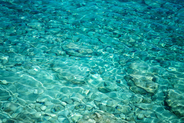 Abstract background and texture, transparent turquoise sea water and stones at the bottom - Φωτογραφία, εικόνα
