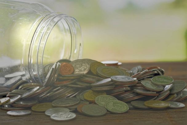 Verter la moneda de la caja de ahorros para la necesidad de utilizar los gastos de manutención. - Foto, imagen