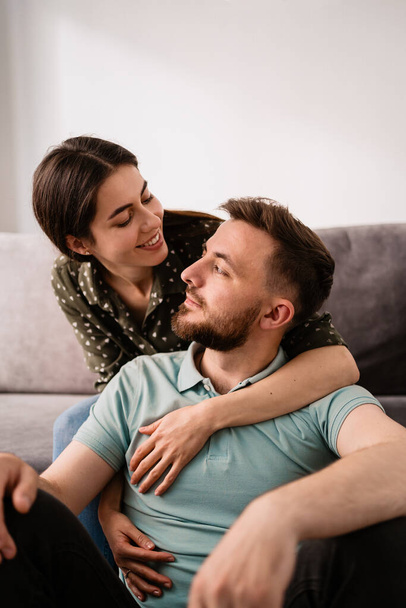 Man and woman portrait smiling to each other on the sofa - Photo, Image