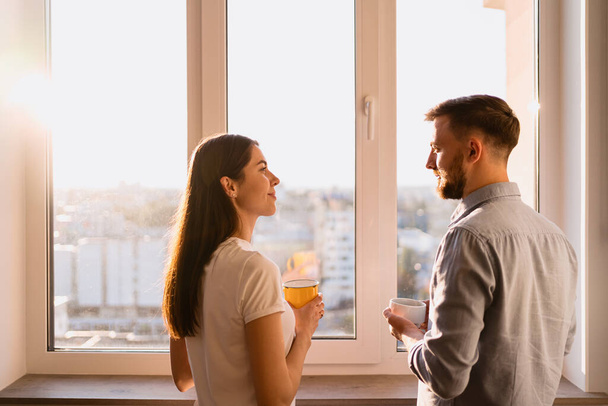 A man and woman drink tea near the window - Photo, Image