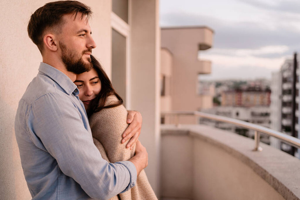 Hombre y mujer en el balcón al atardecer en la ciudad - Foto, Imagen