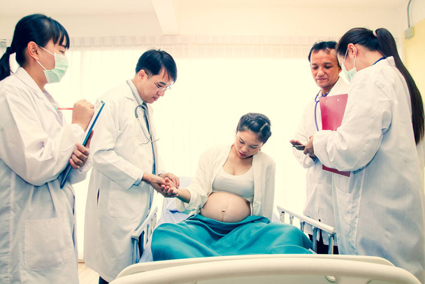 妊娠中の女性の世話をする医師のグループは、安全に子供を出産します。病院のコンセプト、産科、患者の健康管理 - 写真・画像