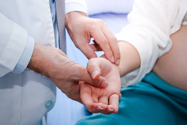 Asian doctors use the pulse hand grip on the right wrist of a Chinese pregnant woman. Patient treatment concept - Photo, Image