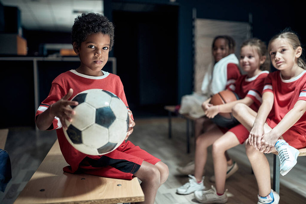 The little soccer players posing before a training in a locker room - Foto, Imagen
