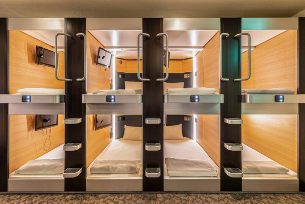 Der zweistöckige Schlafbereich wird in einem modernen Kapselhotel in Japan kombiniert - Foto, Bild