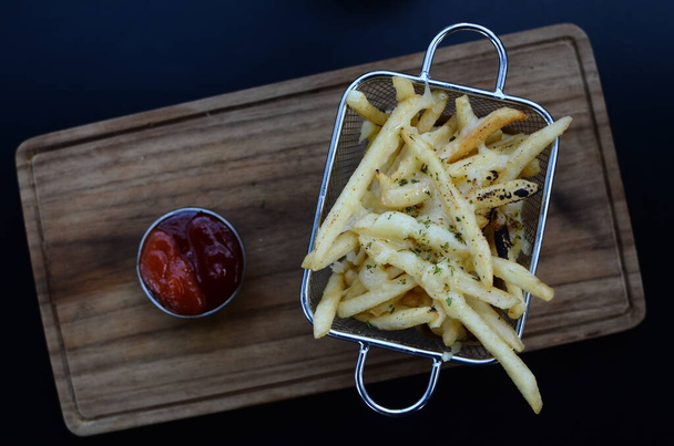 French fries in basket with ketchup and sauce - Foto, afbeelding