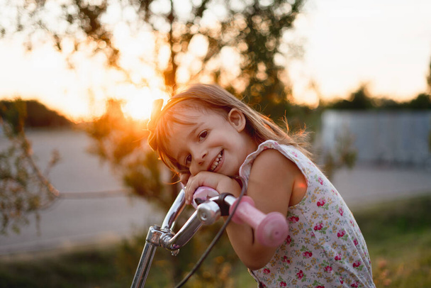 little happy girl child cycling in the sunlight - Foto, imagen