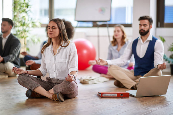 Young colleagues relaxing and having yoga in the office - Foto, Imagem