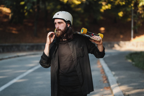The guy with the board smokes a cigarette. Lifestyle style. - Photo, image