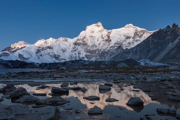 Cholatse mountain reflecting in moraine lakes mirrorlike surface Energetic photo - 写真・画像