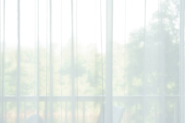 rideau blanc aéré ou mince et transparent avec texture pour voir à travers l'arbre et la lumière douce sur la fenêtre du balcon et fermer dans la chambre pour la décoration intérieure de la maison ou de l'hôtel et le fond de l'architecture lumineuse - Photo, image