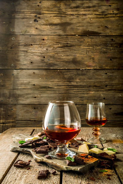 Mocny drink alkoholowy. Szklanka brandy, whisky lub koniaku na drewnianym stole - Zdjęcie, obraz