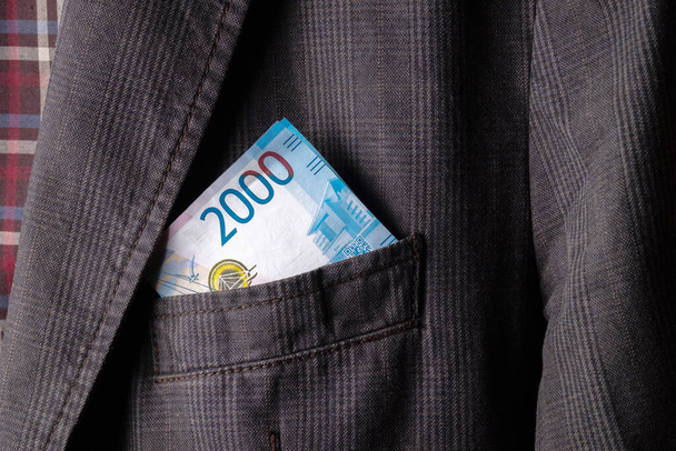 obchod vydělal peníze v kapse všechno se ukázalo, 2000 ruských rublů v kapse šedé bundy - Fotografie, Obrázek