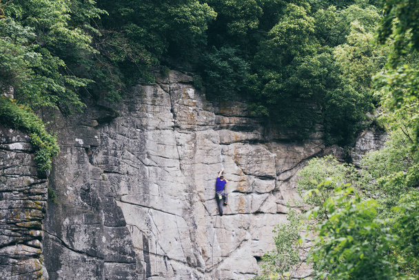 登山家は、ブキキャニオン、ウクライナの石の崖の壁を登る - 写真・画像