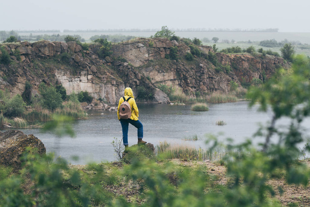 Mujer en impermeable amarillo senderismo en el cañón de montaña - Foto, Imagen