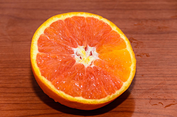 Mezza frutta jucy arancione, da vicino, fondo di legno. - Foto, immagini