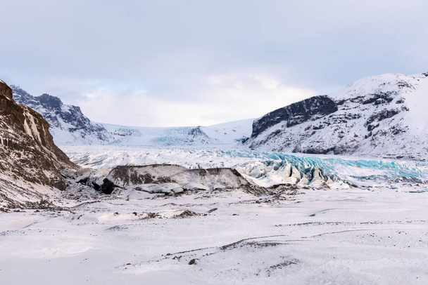 turista cabeza al pie del glaciar en el panorama de las montañas islandesas, el glaciar y el Parque Nacional - Foto, imagen
