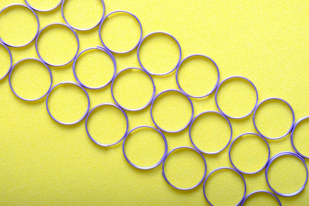 Ringe für Schlüsselanhänger auf gelbem Hintergrund, viele Ringe sind diagonal angeordnet - Foto, Bild