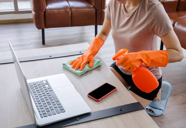 Οι γυναίκες καθαρίζουν το σπίτι με ρούχα και υγρά. Για την προστασία από ιούς, το Corona Covid-19 προλαμβάνει την εξάπλωση του ιού.. - Φωτογραφία, εικόνα