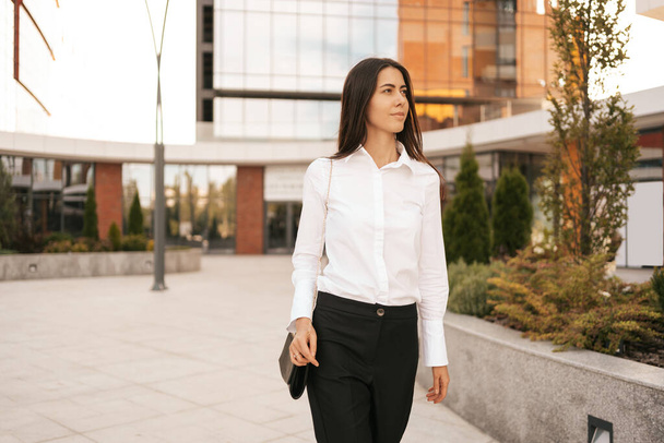 Beautiful woman in white shirt on business buildings background - Photo, Image