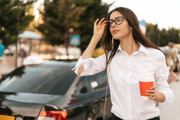Jeune femme d'affaires attrapant un taxi avec un café pour aller - Photo, image