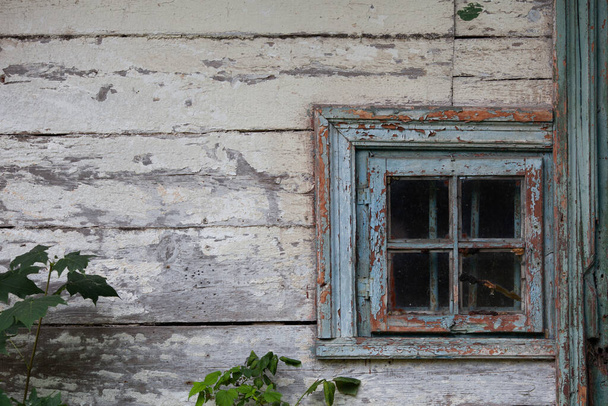 Klasik pencereli çok eski ahşap evin beyaz duvarı. Mavi ahşap pencere, soyulmuş boya, çatlaklar ve çizikler.. - Fotoğraf, Görsel
