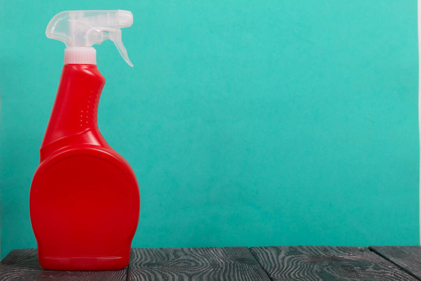 Red plastic bottle with spray. Cleaning spray. On a mint background. - Фото, зображення