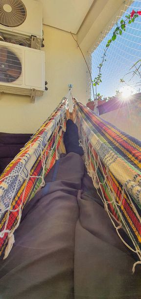 Nohy odpočívající v houpací síti při ranním východu slunce. - Fotografie, Obrázek