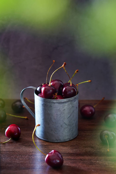 Fresh cherries in a vintage metal mug, isolated - Fotó, kép