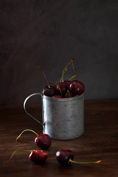 Fresh cherries in a vintage metal mug, isolated - Foto, Bild
