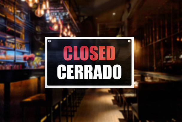 Closed sign of a bar or pub. With English and Spanish translation. Concept of Closure, suspension, or bankruptcy of a bar, restobar or pub. - Photo, Image