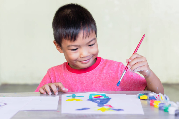 Portré kép 6 éves fiúról. Ázsiai diák rajz és festés színek a papíron a szobában. Tanulmány otthonról, társadalmi távolság, Kölyök és oktatási koncepció. - Fotó, kép