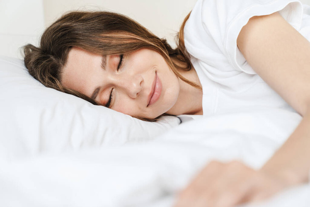 Beyaz yastıkta yatarken uyuyan güzel beyaz kadın görüntüsü. - Fotoğraf, Görsel