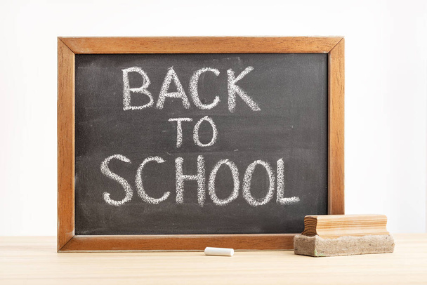 Back to school concept. Chalkboard with handwritten text on table - Φωτογραφία, εικόνα