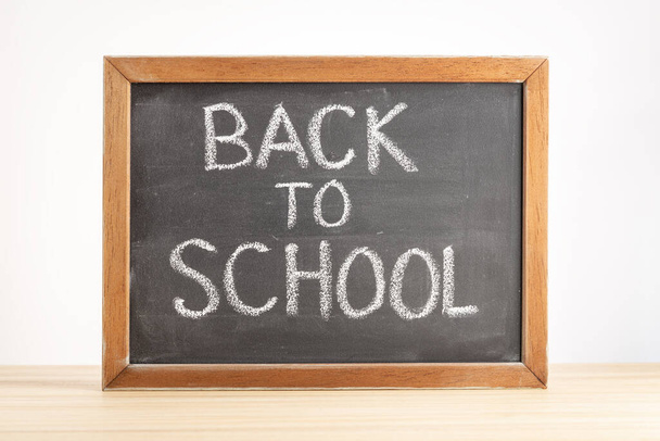 Back to school concept. Chalkboard with handwritten text on table - Fotó, kép
