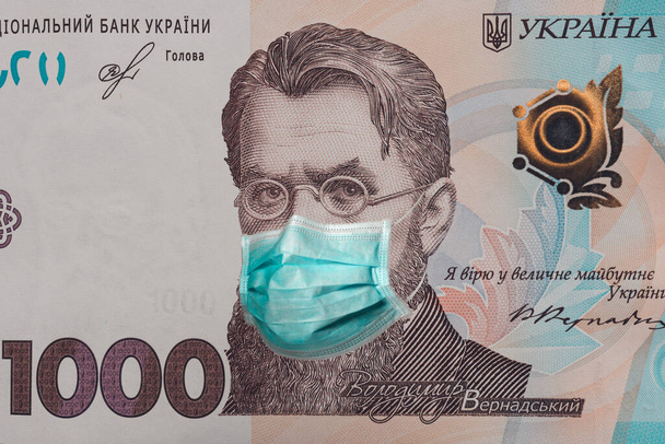Banknot 1000 hrywien przedstawiający Władimira Vernadskiego w masce medycznej podczas kryzysu gospodarczego i pandemii koronawirusa na Ukrainie. Jakościowe zbliżenie montażu. - Zdjęcie, obraz