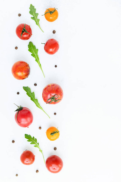 valikoima kirkkaita, kypsiä, monivärisiä tomaatteja, valkoisella kuluneella taustalla. näkymä ylhäältä. satokauden käsite - Valokuva, kuva