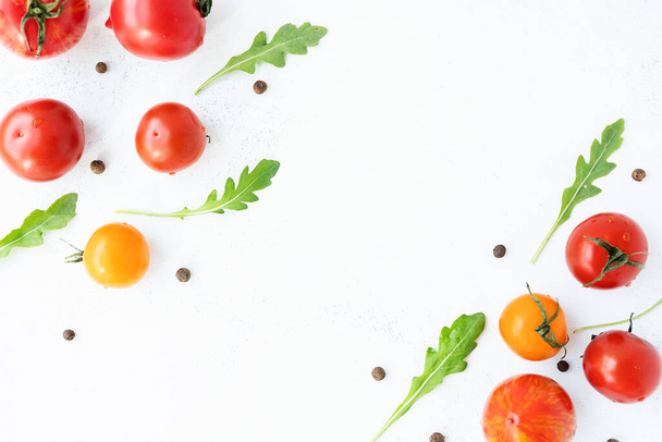 assortiment van heldere, rijpe, veelkleurige tomaten, op een witte versleten achtergrond. het uitzicht vanaf de top. concept van het oogstseizoen - Foto, afbeelding