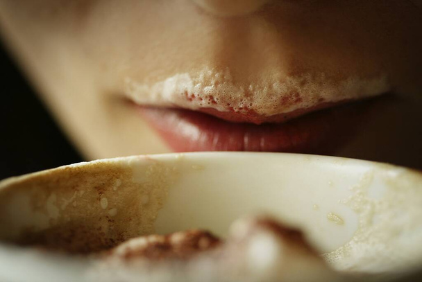 Nuori aikuinen nainen juo kahvia, kahvia Viikset huulilla. - Valokuva, kuva