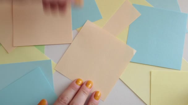 Escreva palavras, números e letras em folhas de notas quadradas multicoloridas
 - Filmagem, Vídeo