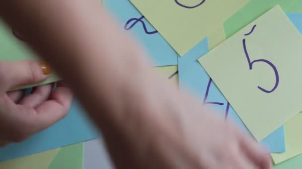 Schreiben Sie Wörter, Zahlen und Buchstaben auf quadratische, mehrfarbige Notizblätter - Filmmaterial, Video