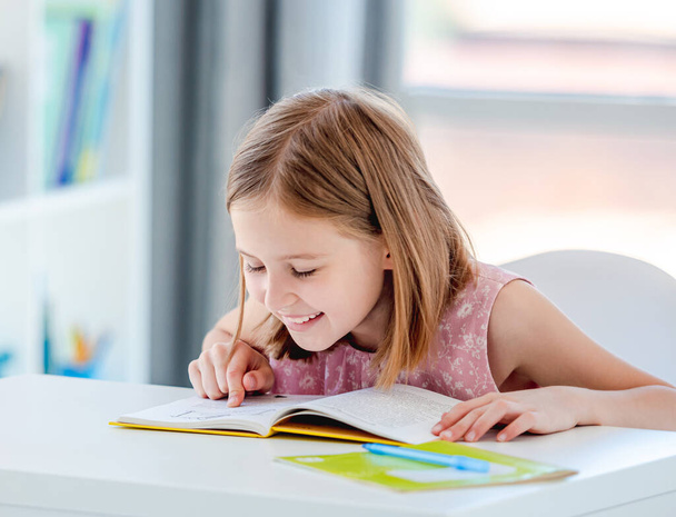 Little girl reading book in classroom - Foto, Imagem