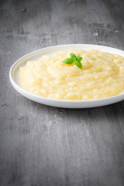Mashed potatoes in white plate on gray wooden background	 - Photo, Image