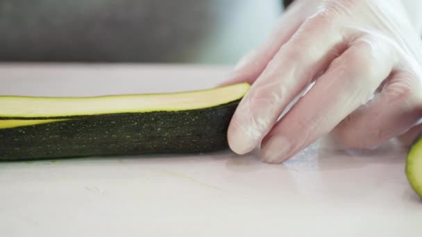Grüne Zucchini auf einem weißen Schneidebrett schneiden. - Filmmaterial, Video