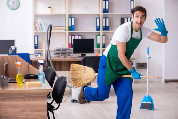 Young handsome contractor cleaning the office - Photo, Image