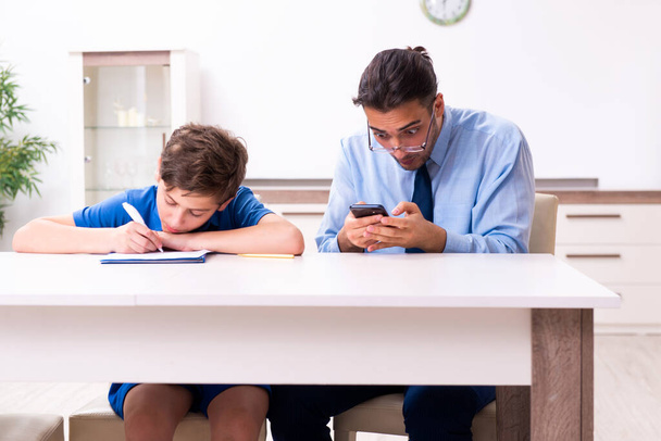 Busy father helping his son to prepare for exam - Photo, Image
