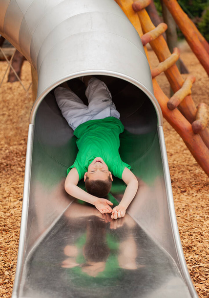 Young Boy Playing On a Slide in a Park - Photo, Image