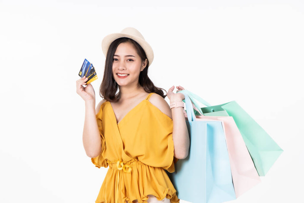 Asian woman in summer casual clothes.Asian Smiling woman .Beautiful Attractive asian woman smile and holding pastel bags on white background,isolated.Shopping happy  concept. - Фото, изображение