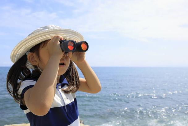 Japans meisje met opera glas aan zee (5 jaar oud) - Foto, afbeelding