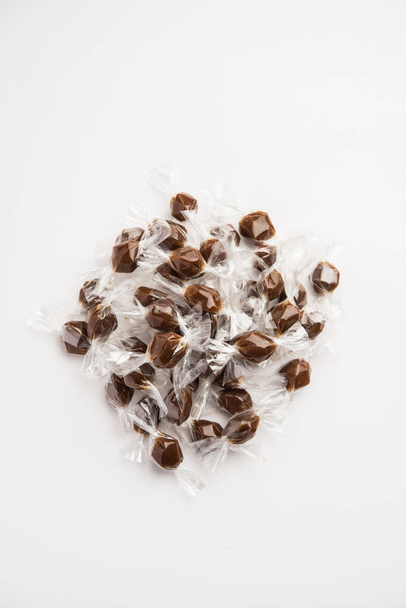Το Tamarind Candy ή Imli pops είναι κατασκευασμένο από πολτό Tamarindus indica και ζάχαρη ή ζάχαρη και τυλιγμένο σε μικρά πλαστικά περιτυλίγματα στριμμένα σε κάθε άκρο - Φωτογραφία, εικόνα
